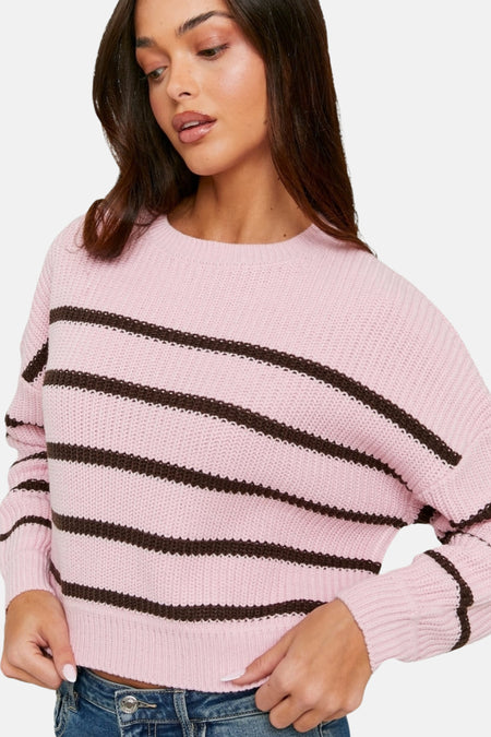 Roze gebreide trui met bruine strepen.
