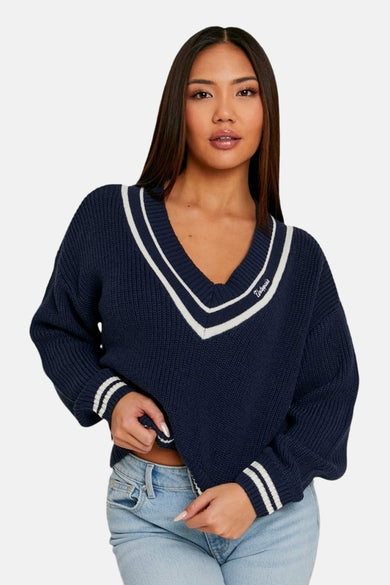 Pull bleu à col en V de TALLY WEIJL, avec des rayures blanches le long de l'encolure et des manches.