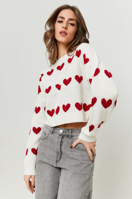 Witte trui met hartjesmotief van TALLY WEIJL, gecombineerd met grijze jeans, staand geposeerd.
