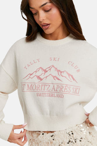 Pull-over blanc avec col rond de TALLY WEIJL, brodé de montagnes roses et du texte "St. Moritz Apres Ski Switzerland".