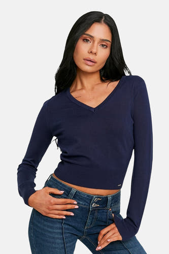 Pull bleu à col en V de TALLY WEIJL, modèle court porté avec un jean.