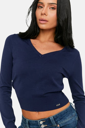 Pull bleu à col en V de TALLY WEIJL, coupe courte et détails de pantalon en jean.