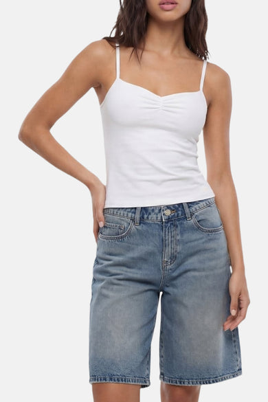 Short en jean bleu moyen de TALLY WEIJL avec une coupe décontractée, porté avec un caraco blanc.