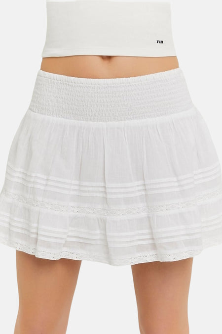 Witte rok van TALLY WEIJL met gesmokte tailleband, gelaagde ruches en kanten details, gedragen met een witte crop top.