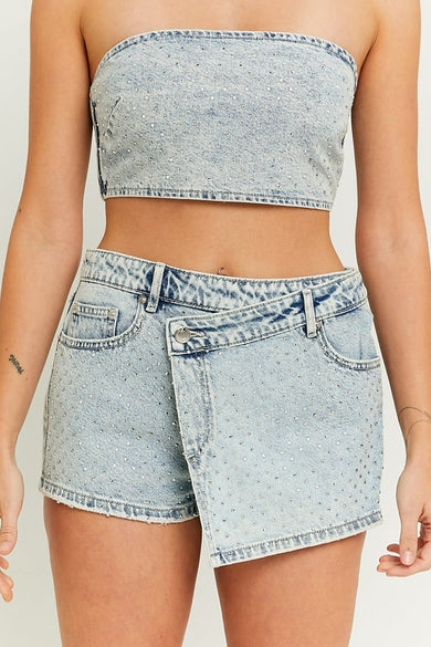 Lichtblauwe denim short van TALLY WEIJL, versierd met zilverkleurige studs en een asymmetrische overslag aan de voorkant.
