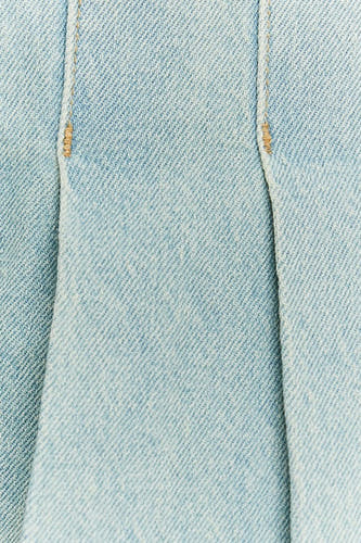 Korte rok van lichtblauw denim van TALLY WEIJL, met stiksels en plooien, close-up.
