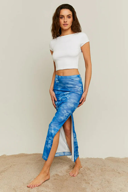 Lange blauwe rok van TALLY WEIJL, met split en wolkprint, gecombineerd met een wit crop topje.
