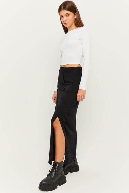 Zwarte lange rok met zijsplit van TALLY WEIJL, gedragen met witte crop top en zwarte laarzen, zijaanzicht