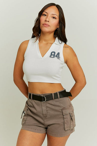 Witte mouwloze top van TALLY WEIJL, met een '84' applicatie en gedragen met bruine cargo shorts en zwarte riem.
