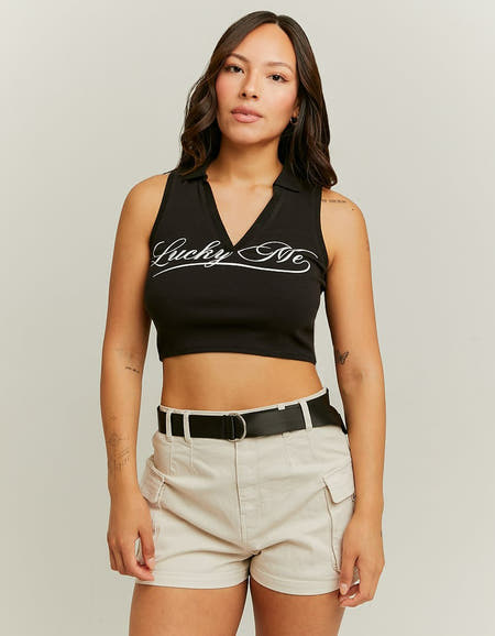 Zwarte top zonder mouwen van TALLY WEIJL, met opschrift, gecombineerd met beige shorts en riem.