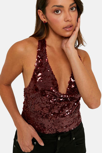 Blouse sans manches rouge de TALLY WEIJL, finie avec des paillettes brillantes et portée avec un pantalon noir.
