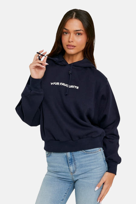 Blauwe sweater met kap van TALLY WEIJL met witte tekst, gecombineerd met een jeans.
