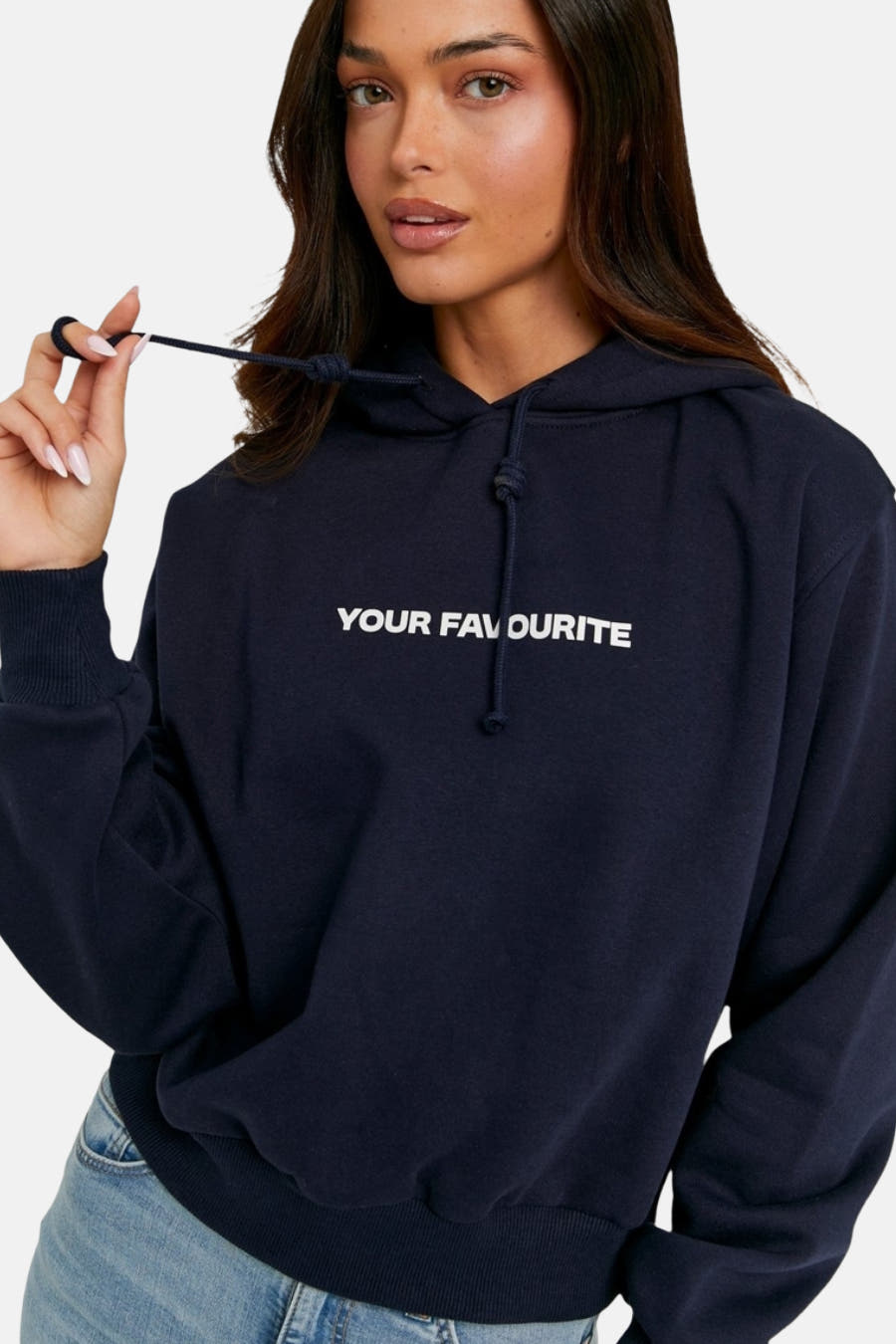 Blauwe sweater met kap van TALLY WEIJL, met wit opschrift en een jeans zichtbaar.
