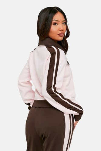 Roze gilet van TALLY WEIJL, met bruine strepen op de mouwen en bruine broek.