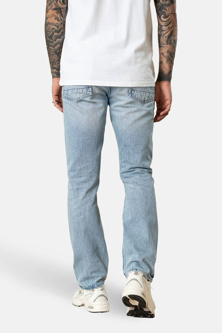 Straight jeans van lichtblauw denim van Petrol Industries®, gezien van achteren, met zakken en witte sneakers.
