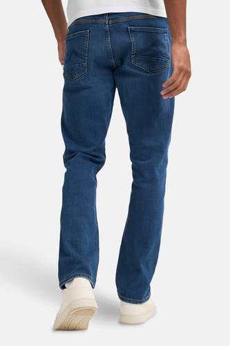 Blauwe rechte jeans van Petrol Industries, gezien van achteren, met witte sneakers.
