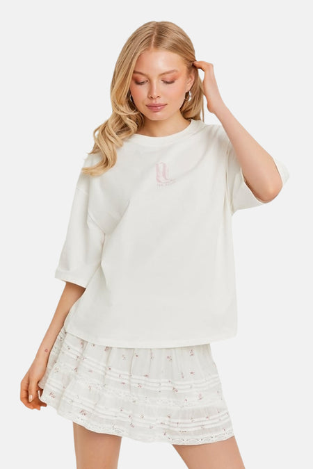 T-shirt blanc ample de TALLY WEIJL avec un imprimé bottes roses et un logo sur la poitrine.
