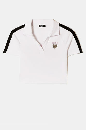Witte polo met korte mouwen van TALLY WEIJL, met een zwarte streep op de mouw en een print met het jaartal 1984.