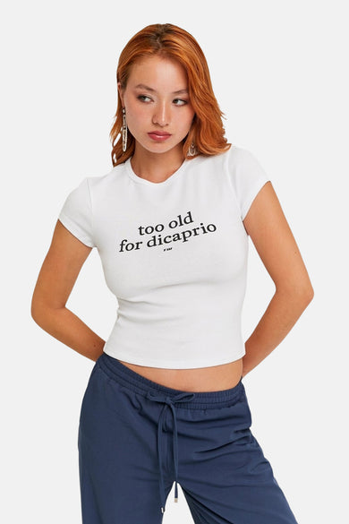 Wit T-shirt met korte mouwen van TALLY WEIJL, met de tekst "too old for dicaprio", gecombineerd met blauwe joggingbroek.
