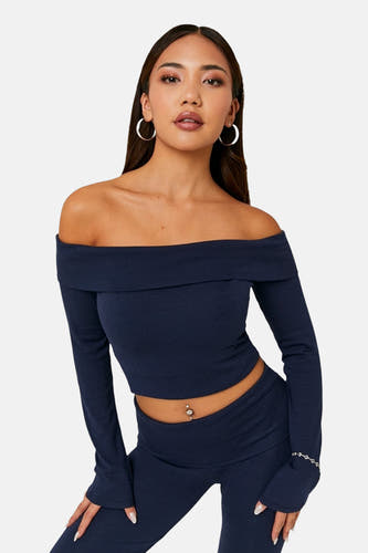 Blauw T-shirt met lange mouwen van TALLY WEIJL, met off-shoulder halslijn, gedragen met bijpassende broek en zilveren oorbellen.
