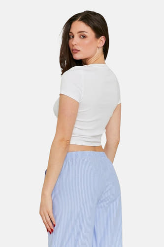 T-shirt blanc à manches courtes de TALLY WEIJL, porté avec un pantalon rayé bleu.