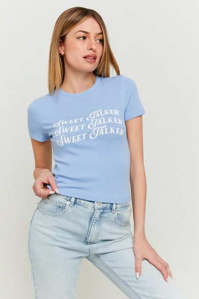 Blauw T-shirt met korte mouwen van TALLY WEIJL, met de tekst "Sweet Talker" erop, gecombineerd met een spijkerbroek.
