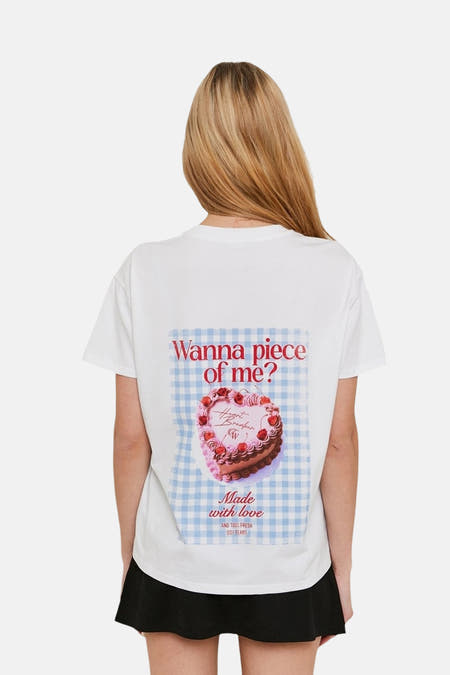 Wit T-shirt met korte mouwen van TALLY WEIJL, met print van een taart op de rug, gedragen met een zwarte rok.
