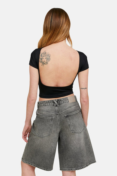 T-shirt noir à manches courtes de TALLY WEIJL, avec dos nu et tatouages sur le dos et le bras.