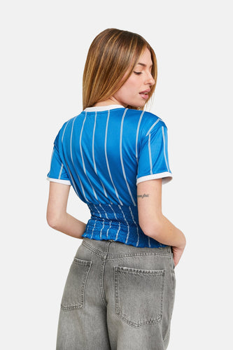 Vrouw in blauw gestreept shirt en grijze jeans.