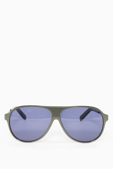 Lunettes de soleil vertes de SUNSET STUDIO avec des verres bleus et un cadre en plastique.