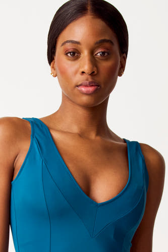 Paquet turquoise de SUNSET STUDIO, avec une encolure découpée et des détails brodés.
