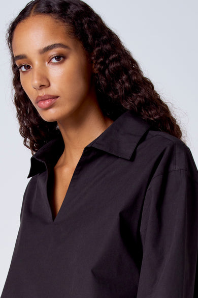 Zwarte blouse met lange mouwen van SUNSET STUDIO, met een open kraag en gladde textuur.
