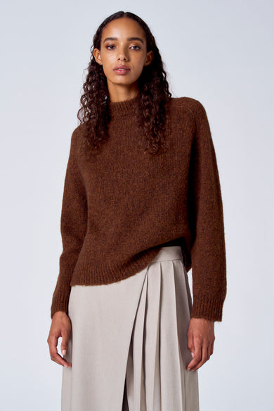 Sweat-shirt marron avec col rond de SUNSET STUDIO, montré sur un modèle en pantalon crème vu de l'arrière.