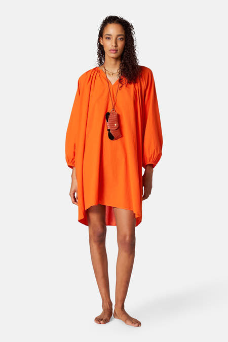 Robe orange avec longues manches de SUNSET STUDIO, avec une chaîne à lunettes.