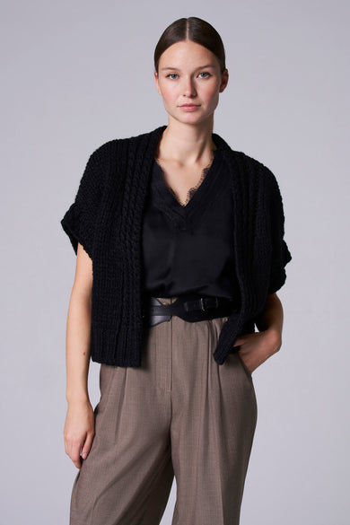 Zwart denim gilet van Astrid Black Label, gedragen over een zwarte top en bruine pantalon.