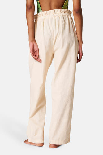 Pantalon beige de SUNSET STUDIO, avec une ceinture élastique et une coupe décontractée, vu de derrière.