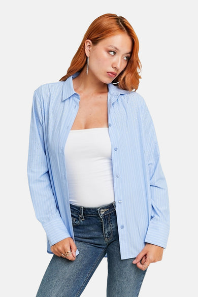 Chemise bleue à rayures de TALLY WEIJL, avec des manches longues et des détails argentés, associée à une chemise blanche et des jeans.