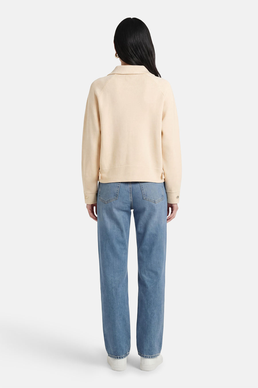 Ecru vest van ADORE, gezien van achteren, gecombineerd met jeans en witte schoenen.