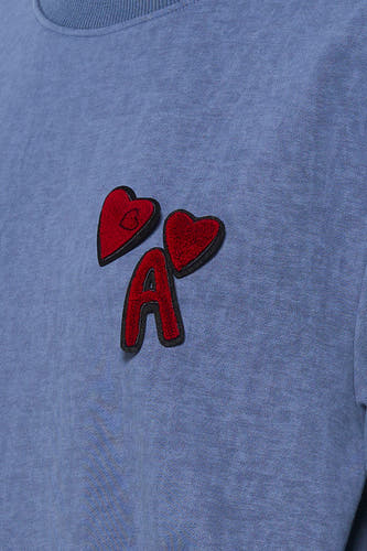 Blauwe sweater van ADORE, met rode hart- en letterpatches op de borst.
