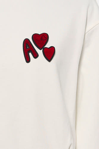 Witte sweater van ADORE met rode letter "A" en hartjes applicaties.

