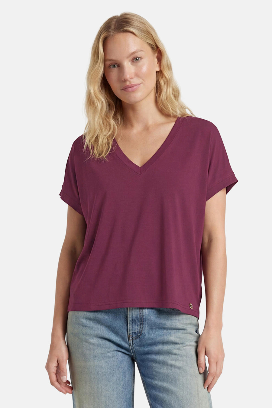Paarse V-hals T-shirt van ADORE, licht vloeiende stof, model draagt met blauwe jeans, front view