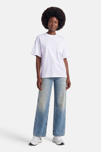 Witte korte mouwen t-shirt met borstzakje van ADORE, gedragen met wijde jeans en witte sneakers, front view