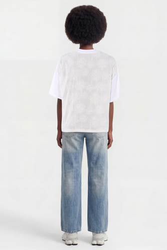 Witte korte mouwen t-shirt met bloemenprint op rug, van ADORE, gedragen met lichtblauwe jeans en witte sneakers, achterkant weergegeven