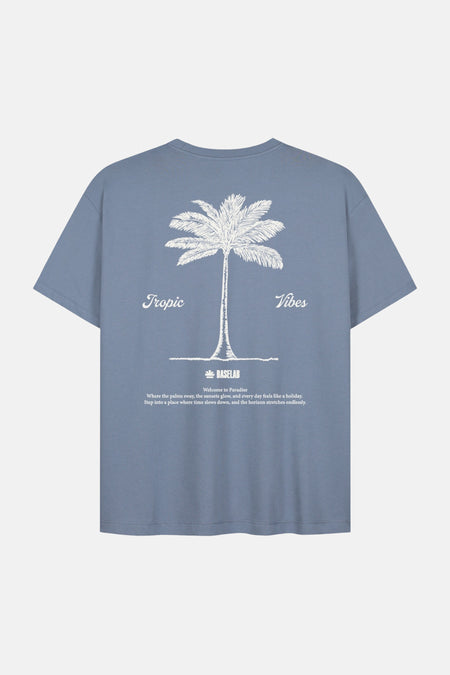 Blauwe korte mouw t-shirt van BASELAB met witte palmboom print en 'Tropic Vibes' tekst op de rug, lifestyle achterkant weergave