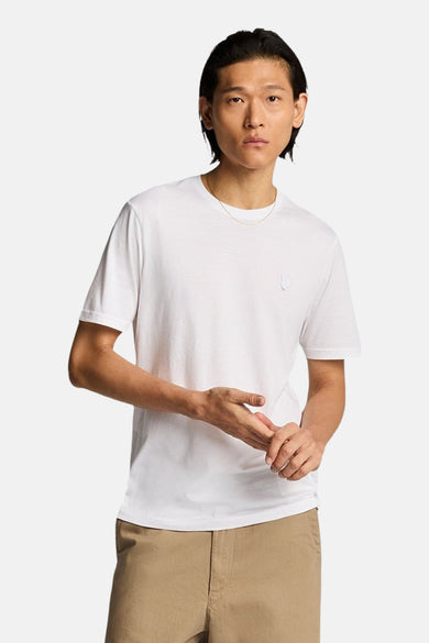 Wit T-shirt met korte mouwen van LYLE & SCOTT, met subtiel adelaarlogo op de borst, gedragen door een man met gouden ketting en beige broek.