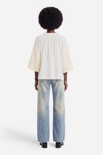 Witte blouse met lange mouwen van ADORE, rugzijde met ruches en crèmekleurige geborduurde mouwuiteinden, gedragen met wijde jeans