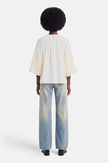 Witte blouse met lange mouwen van ADORE, rugzijde met ruches en crèmekleurige geborduurde mouwuiteinden, gedragen met wijde jeans