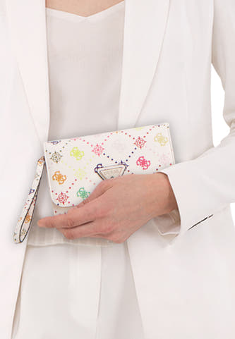 Meerkleurige dames portemonnee van Guess met diverse patronen en polsband, gedragen door een model in een witte outfit.