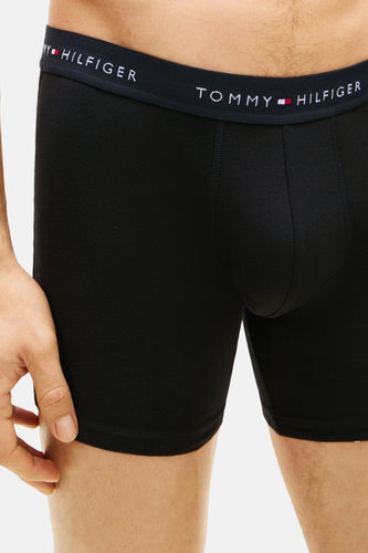 Zwarte boxershort van TOMMY HILFIGER, close-up van het model met een elastische band met het logo.