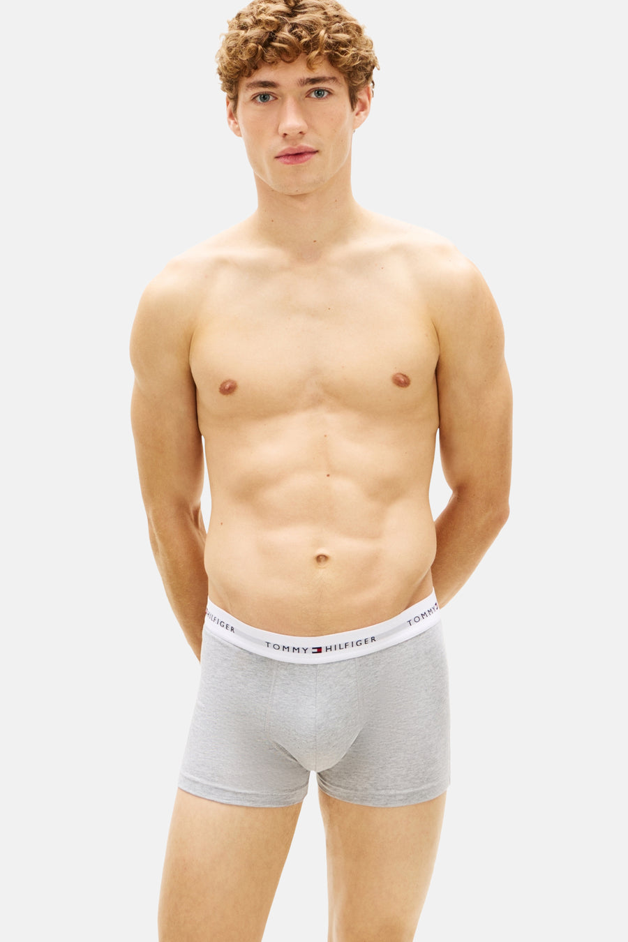 Grijze boxershort van Tommy Hilfiger, gedragen door een man zonder shirt.
